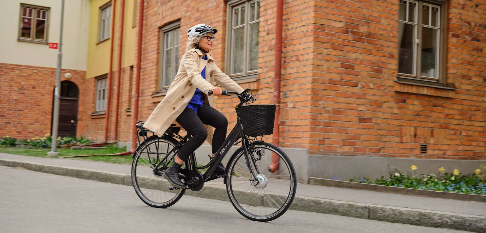 Mogen kvinna på elcykel i stadsmiljö